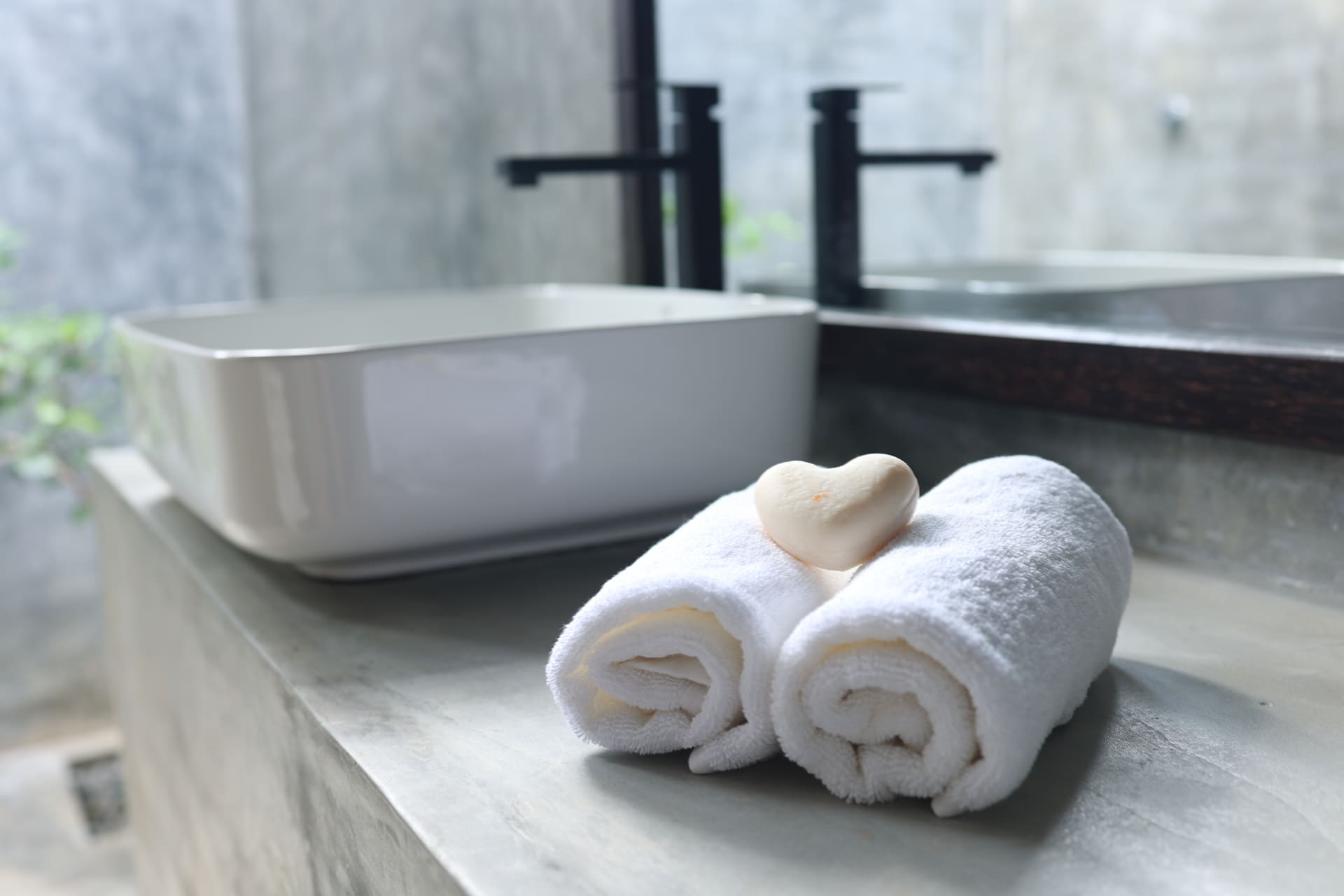 Stone-walled bathroom at the lakeside cottage — open sky, no roof