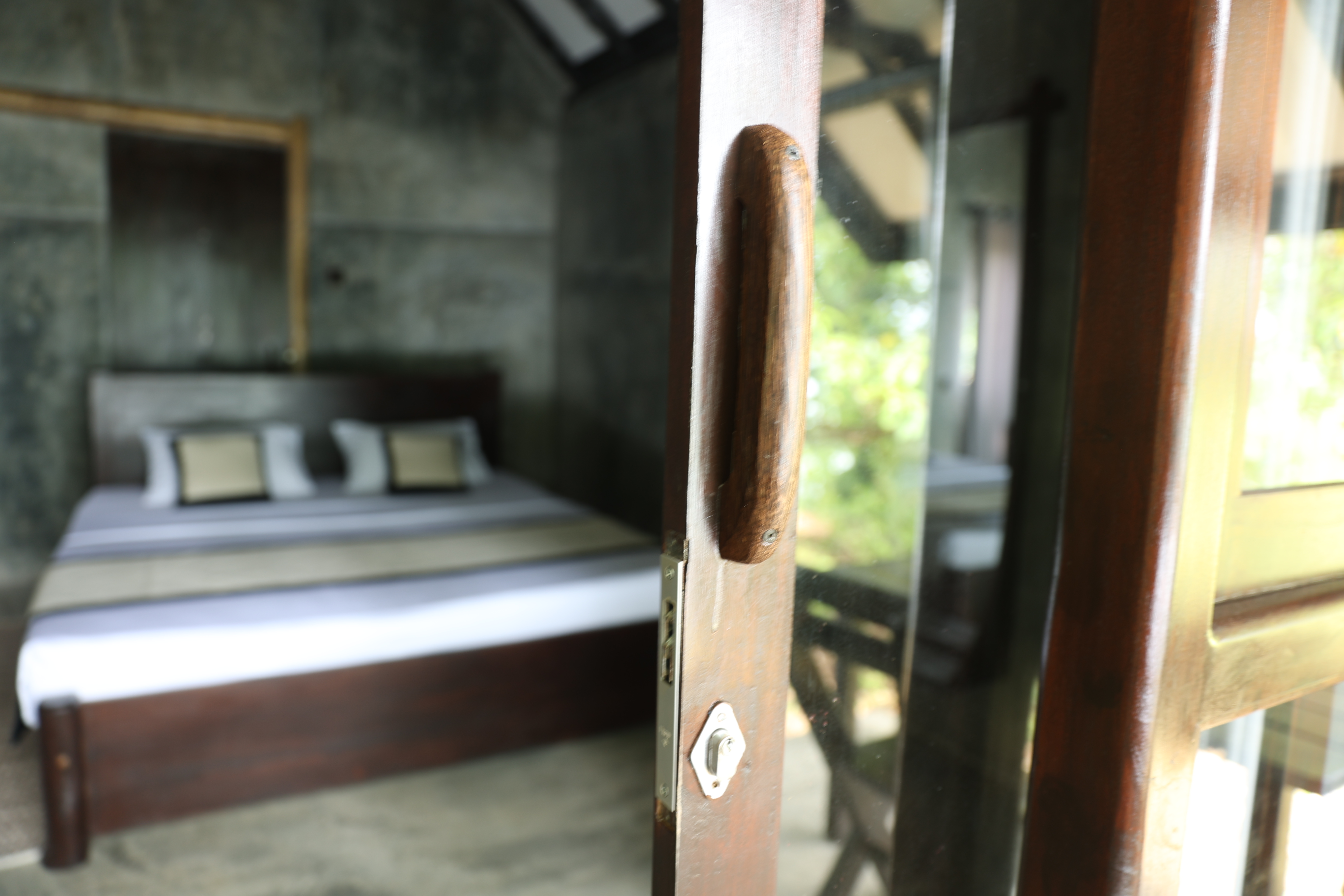 Cottage entrance — bed beyond the teak door